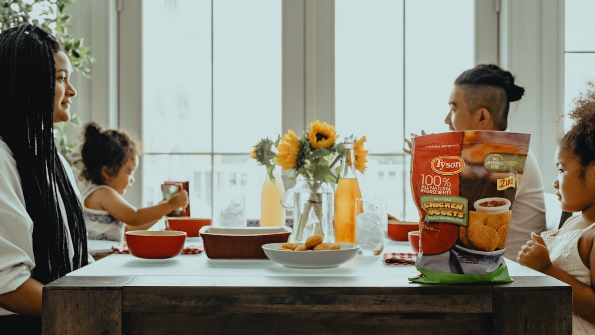 woman in black tank top sitting on chair in front of table with orange ceramic bowl